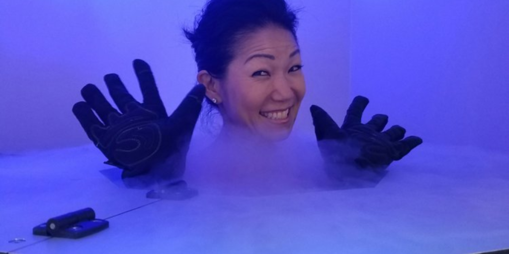 A woman wearing gloves relaxes in a hot tub, highlighting safety precautions for cryotherapy treatments.