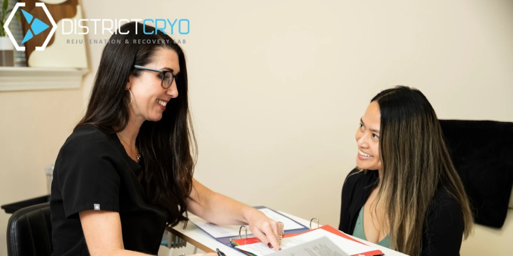 Two women sitting at a desk, focused on a laptop, discussing health and wellness topics related to weight management.